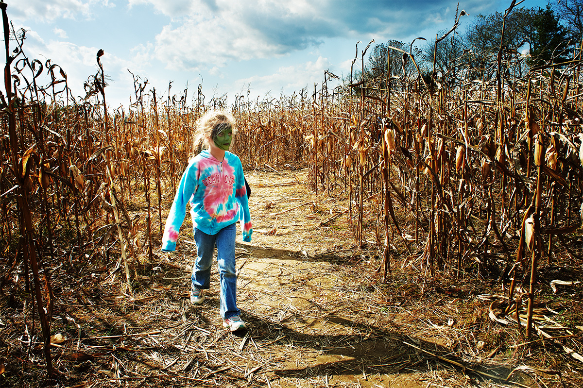 Girl with green face paint in cornfield